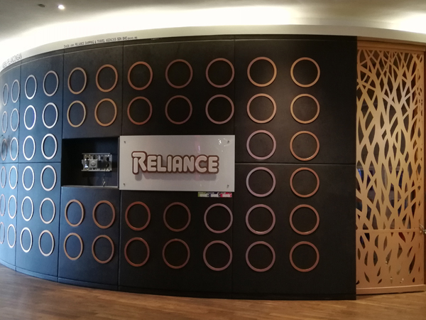 The shuttered Reliance storefront — a curved dark feature wall of circular motifs with the illuminated Reliance sign, the branch closed